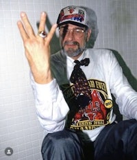 a man sitting on a toilet with a ring on his finger