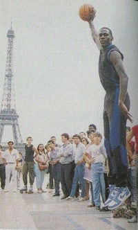 a man with a basketball in front of the eiffel tower